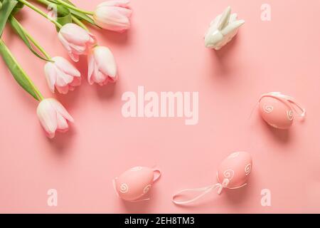 Ostern rosa Komposition für Grußkarte mit Eiern, Hase, Tulpen auf rosa Hintergrund. Blick von oben. Stockfoto