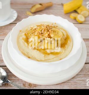 Hirsepudding mit karamellisierten Bananen und Nüssen. Stockfoto