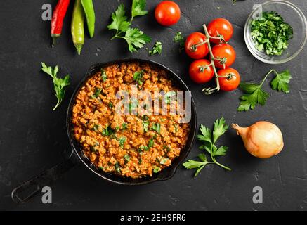 Keema Curry in Bratpfanne auf schwarzem Stein Hintergrund. Indische und pakistanische Gerichte. Draufsicht, flach liegend Stockfoto