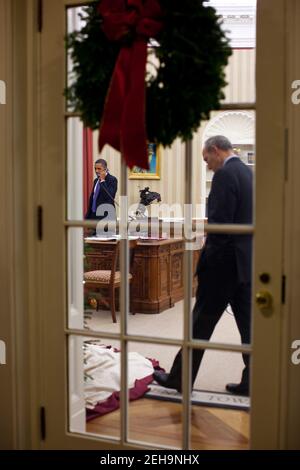 Phil Schiliro, Assistent des Präsidenten für Legislative Angelegenheiten, hört zu, wie Präsident Barack Obama am Telefon mit einem Kongressabgeordneten im Oval Office spricht, 2. Dezember 2010. Stockfoto