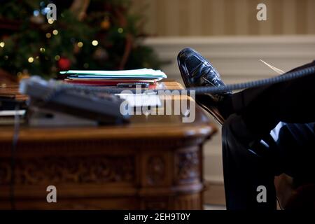 Präsident Barack Obama ruht seinen Fuß auf dem Resolute Desk während eines Anrufs mit dem britischen Premierminister David Cameron im Oval Office, 21. Dezember 2010. Stockfoto