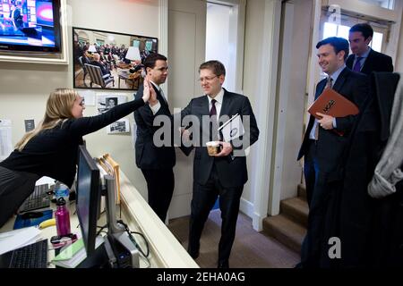 Der Pressesprecher des Weißen Hauses Jay Carney gibt der Presseassistentin Caroline Hughes vor seinem ersten Briefing im James S. Brady Press Briefing Room im Weißen Haus, 16. Februar 2011, einen High-Five im unteren Pressebüro. Beobachten, von links, sind: Stellvertretender Pressesprecher Bill Burton, stellvertretender Pressesprecher Josh Ernest und stellvertretender Pressesprecher Reid Cherlin. Stockfoto