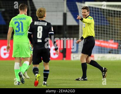 Bielefeld, Deutschland. Februar 2021, 19th. Fußball: Bundesliga, Arminia Bielefeld - VfL Wolfsburg, Matchday 22 in der Schüco Arena. Schiedsrichter Felix Brych spricht mit den Spielern. WICHTIGER HINWEIS: Gemäß den Bestimmungen der DFL Deutsche Fußball Liga und des DFB Deutscher Fußball-Bund ist es untersagt, im Stadion und/oder des Spiels aufgenommene Fotos in Form von Sequenzbildern und/oder videoähnlichen Fotoserien zu verwenden oder zu verwenden. Kredit: Friso Gentsch/dpa/Alamy Live Nachrichten Stockfoto