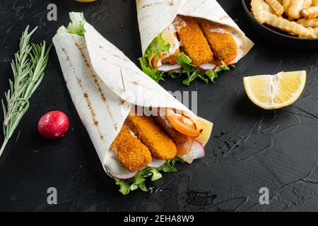 Tortilla Rolle mit Fischfinger, Käse und Gemüse Set, auf schwarzem Hintergrund, mit Copyspace und Platz für Text Stockfoto