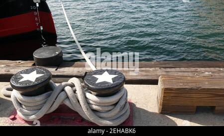 Geknotet auf metallischem Poller mit Sternen, Seefahrernhafen von San Diego, Kalifornien. Seeschiff im Dock vertäut. Kabelbinder am Span befestigt. Symbol Stockfoto