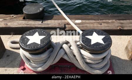 Geknotet auf metallischem Poller mit Sternen, Seefahrernhafen von San Diego, Kalifornien. Seeschiff im Dock vertäut. Kabelbinder am Span befestigt. Symbol Stockfoto