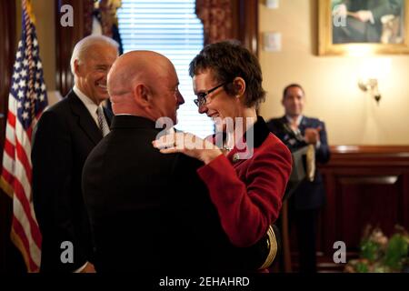 Kapitän Mark Kelly umarmt seine Frau, Kongressabgeordnete Gabrielle Giffords, nachdem er die Legion of Merit von Vizepräsident Joe Biden während einer Ruhestandszeremonie in der Secretary of war Suite im Eisenhower Executive Office Building, in Washington, D.C., am 6. Oktober 2011 empfangen hatte. Stockfoto