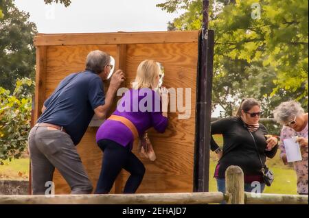 9-30-2018 Alma USA - Rückseite eines Paares mit dem posiert Kopf in Gesicht in Kopfbrett beim Weinfest während Zwei Freunde überprüfen die Bilder, die sie gerade gemacht haben Stockfoto