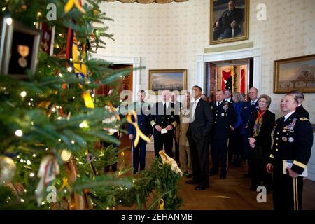 Präsident Barack Obama zeigt Militärbeamten den Weihnachtsbaum des Weißen Hauses im Blauen Raum nach einem Treffen am 1. Dezember 2011. Die 18-Fuß-6 Zoll Balsamtanne wurde mit Weihnachtskarten von Militärkindern und Ornamenten mit Medaillen, Abzeichen und Patches aus allen militärischen Niederlassungen geschaffen verziert. Stockfoto