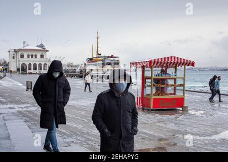 Menschen, die bei starkem Schneefall an der Küste von Kadikoy spazieren. Zum ersten Mal nach einer langen Pause wurde Istanbul am Februar mit starkem Schneefall weiß Stockfoto