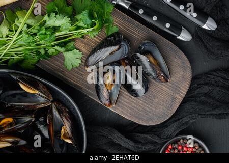 Klassische französische Mahlzeit Moules Mariniere Marinara Set, in Schale, auf schwarzem Hintergrund, Draufsicht flaches Lay Stockfoto