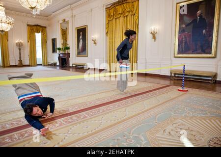 First Lady Michelle Obama nimmt an einem Kartoffelsackrennen mit Jimmy Fallon im East Room des Weißen Hauses Teil, während einer „Late Night with Jimmy Fallon“-Aufnahme zum zweiten Jahrestag der „Let’s Move!“ Initiative, 25. Januar 2012. Stockfoto