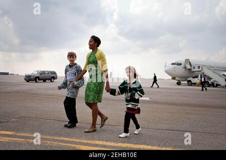 First Lady Michelle Obama geht mit Megan Soukup, 9, und Joseph Hudella, 10, Teilnehmern am Programm Defending the Blue Line, über den Asphalt, während sie sich darauf vorbereitet, Militärfamilien in Minneapolis-St. zu begrüßen Paul International Airport in Minneapolis, Minn., 16. März 2012. Die First Lady reiste nach Minnesota, um Familien der Nationalgarde und lokale Gemeindeführer zu treffen, die sich der Unterstützung von Militärfamilien verschrieben haben. Stockfoto