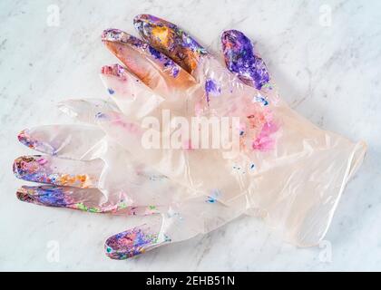 Handschuhe aus durchsichtigen Latex eines Künstlers, mit Farbspritzern überzogen. Stockfoto