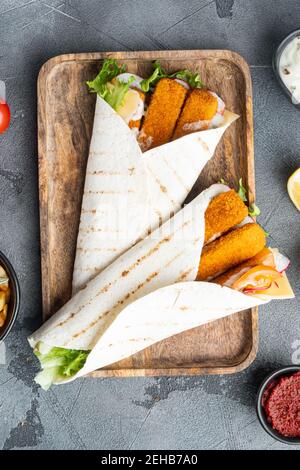 Fischfinger Rollen und Tartar Sauce Set, auf Holztablett, auf grauem Hintergrund, Draufsicht flach legen Stockfoto