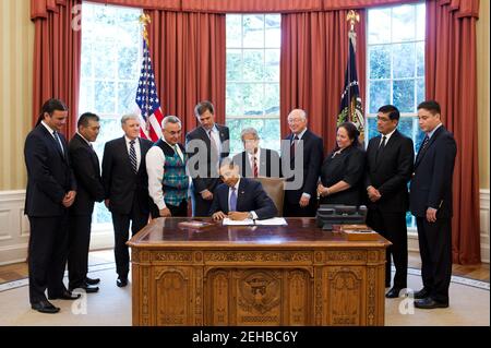 Präsident Barack Obama unterzeichnet H.R. 205, HEARTH Act von 2012, im Oval Office, 30. Juli 2012. Hinter dem Präsidenten stehen von links: Bryan Newland, Senior Policy Advisor im Innenministerium; Gouverneur Randall Vicente, Pueblo von Acoma in New Mexico; David Hayes, stellvertretender Sekretär des Innenministeriums; Jefferson Keel, Präsident des Nationalkongresses der amerikanischen Indianer; Rep. Martin Heinrich, D-N.M.; Sen. Daniel Akaka, D-Hawaii; Innenminister Ken Salazar; Cheryl Causley, Vorsitzender des National American Indian Housing Council; Gouverneur Gregory Mendoza Stockfoto