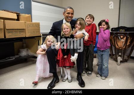 16. Dezember 2012 zwei Tage nach den Erschießungen in Newtown reiste der Präsident nach Connecticut, um sich mit den Familien der Opfer zu treffen und bei einer Gebetswache Bemerkungen zu machen. Der Präsident verbrachte Stunden mit der Begrüßung von Familienmitgliedern. So schwierig das für alle war, der einzige Moment, der den Schmerz besänfnete, war, als er für ein Foto mit den Geschwistern und Cousins von Emilie Parker posierte, einem der 20 Kinder, die an diesem Tag in Newtown starben. Ich sehe Traurigkeit und Hoffnung in diesem Foto, und ich weiß, dass es nach vielen Tränen an diesem Tag so viel für den Präsidenten bedeutet hat, dass jeder einen Moment lang lächeln konnte Stockfoto