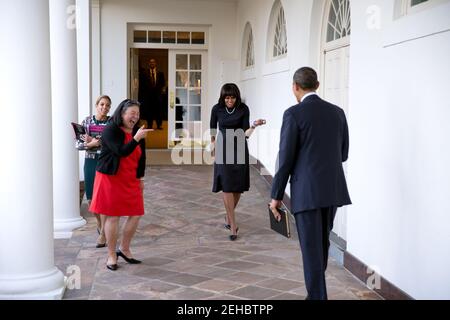 Präsident Barack Obama sieht zu, wie First Lady Michelle Obama ihn am 12. Februar 2013 in der Kolonnade des Weißen Hauses spielerisch begrüßt. Tina Tchen, Stabschefin der First Lady, und persönliche Aide Kristin Jones, gingen, begleiten Frau Obama. Stockfoto