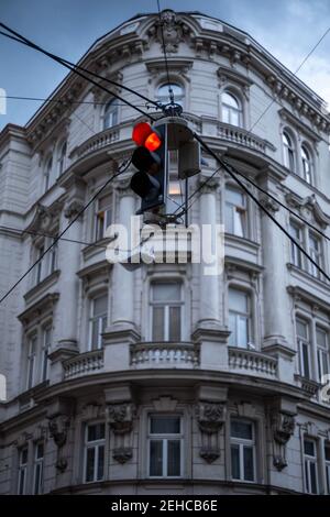 Eine rote Ampel vor einem prunkvollen Wohnhaus in Wien, Österreich Stockfoto