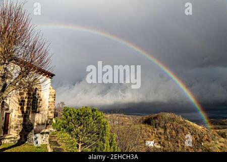 Montaigut-le-Blanc, Frankreich. Februar 2021, 10th. Regenbogen über der Stadt Montaigut-le-Blanc im Departement Puy-de-Dôme, in der Auvergne-Rhône-Alpes. Stockfoto