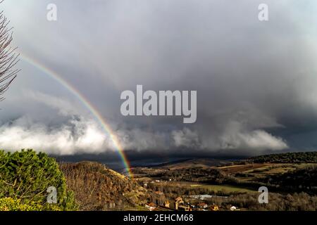 Montaigut-le-Blanc, Frankreich. Februar 2021, 10th. Regenbogen über der Stadt Montaigut-le-Blanc im Departement Puy-de-Dôme, in der Auvergne-Rhône-Alpes. Stockfoto