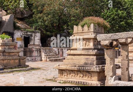 Anegundi, Karnataka, Indien - 9. November 2013: Navabrindavana Insel und Tempel. Nahaufnahme eines ruinösen braunen Steingebäudes mit grünem Laubschirm Stockfoto