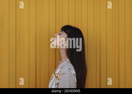 Crop anonyme Gärtnerin in Schürze stehen mit frischen blühenden lila Hyazinthen Blumen im Topf Stockfoto