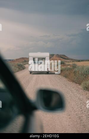 Durch Auto Seitenspiegel Ansicht der geraden Fahrbahn mit Wohnwagen Gegen Berg ländliche Landschaft Stockfoto
