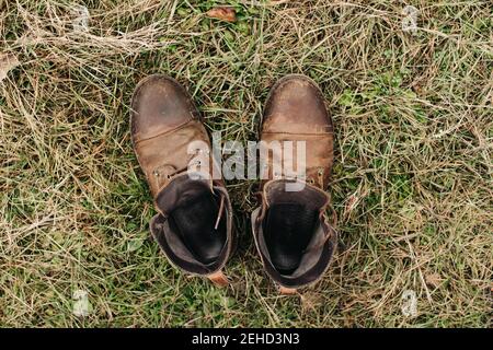 Draufsicht auf ein Paar abgenutzter brauner Lederschuhe platziert Auf Rasen in der Natur Stockfoto