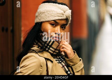 Porträt einer asiatischen Frau mit einem braunen Turban, der auf der Straße posiert Stockfoto