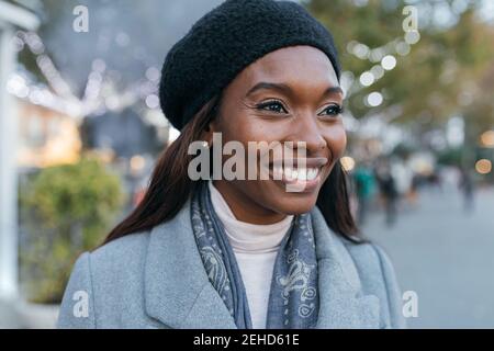Nahaufnahme afroamerikanische weibliche aufstehen in Oberbekleidung Straße und Mit Kopfhörern Stockfoto