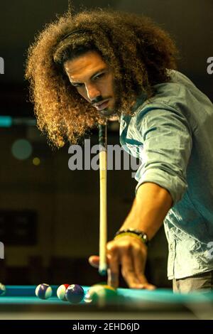 Crop fokussierten bärtigen Mann schlagen Ball mit Queue während des Spielens Spiel im Billard-Pool Stockfoto