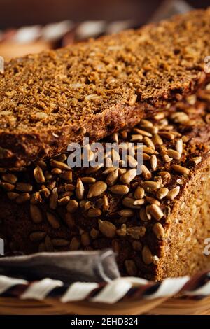Nahaufnahme von schmackhaftem geschnittenem Brot mit brauner Kruste und knusprig Sonnenblumenkerne oben im Weidenkorb Stockfoto