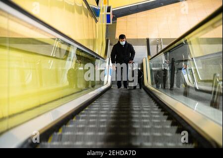 Blinder Mann, der mit Blindenhund auf der Rolltreppe läuft Stockfoto