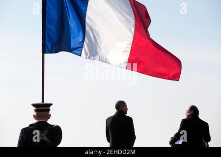 Ein Mitglied des Farbschutzes hält eine französische Flagge, während Präsident Barack Obama den Ausführungen des französischen Präsidenten François Hollande während der Zeremonie zur Ankunft des Staates auf dem Südrawn des Weißen Hauses am 11. Februar 2014 zuhört. Stockfoto
