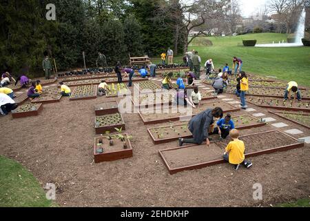 First Lady Michelle Obama schließt sich FoodCorps Führern und lokalen Studenten für den Frühlingsgarten Pflanzen im Weißen Haus Kitchen Garden, 2. April 2014. Stockfoto