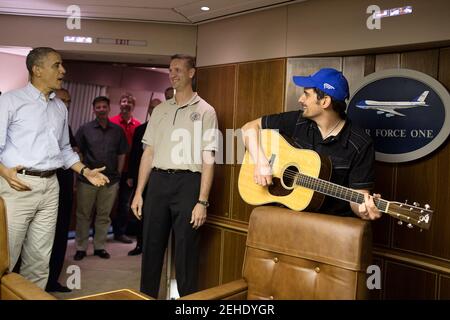 Präsident Barack Obama singt Happy Birthday für Rob Nation, den Superintendent der Flugbegleiter des Präsidenten, während Country-Sänger Brad Paisley auf Air Force One Gitarre spielt auf der Heimreise von Truppen in Afghanistan, Sonntag, den 25. Mai 2014. Stockfoto