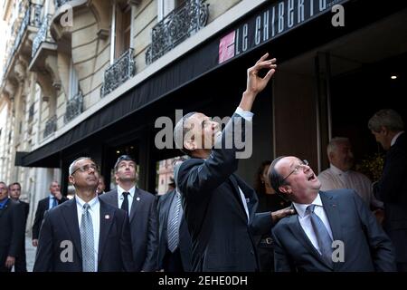 Präsident Barack Obama schaut auf und winkt, als er und der französische Präsident François Hollande nach dem Abendessen in Paris, Frankreich, am 5. Juni 2014, ein Restaurant verlassen. Stockfoto