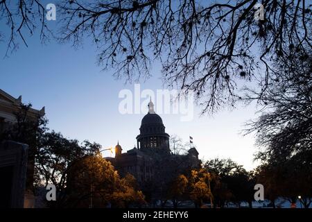 Austin, Usa . Februar 2021, 19th. Austin, Texas 19. Feb 2021: Die Sonne geht über einem Texas Capitol auf, das am sechsten Tag des Winterwetters, das viel von einem unvorbereiteten Lone Star Zustand gelähmt hat, abgedunkelt wurde, um Energie zu sparen. Wärmeres Wetter wird es Texanern ermöglichen, umfangreiche Schäden an Wassersystemen, Bäumen und Straßen zu kontrollieren. Kredit: Bob Daemmrich/Alamy Live Nachrichten Stockfoto