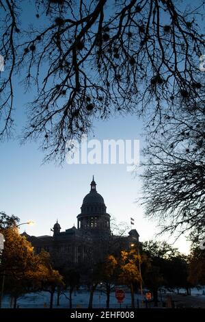 Austin, Usa . Februar 2021, 19th. Austin, Texas 19. Feb 2021: Die Sonne geht über einem Texas Capitol auf, das am sechsten Tag des Winterwetters, das viel von einem unvorbereiteten Lone Star Zustand gelähmt hat, abgedunkelt wurde, um Energie zu sparen. Wärmeres Wetter wird es Texanern ermöglichen, umfangreiche Schäden an Wassersystemen, Bäumen und Straßen zu kontrollieren. Kredit: Bob Daemmrich/Alamy Live Nachrichten Stockfoto