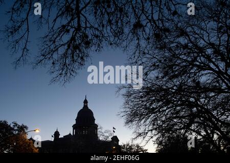 Austin, Usa . Februar 2021, 19th. Austin, Texas 19. Feb 2021: Die Sonne geht über einem Texas Capitol auf, das am sechsten Tag des Winterwetters, das viel von einem unvorbereiteten Lone Star Zustand gelähmt hat, abgedunkelt wurde, um Energie zu sparen. Wärmeres Wetter wird es Texanern ermöglichen, umfangreiche Schäden an Wassersystemen, Bäumen und Straßen zu kontrollieren. Kredit: Bob Daemmrich/Alamy Live Nachrichten Stockfoto