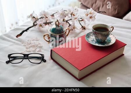 Stillleben eines Buches, Kaffeetassen und Mandelblüten. Lesekonzept