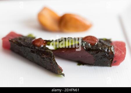Thunfisch in Algen Vorspeise auf weißem Teller Hintergrund eingewickelt Stockfoto