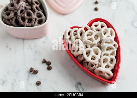 Frische Schokolade und Joghurt getauchte Brezeln in Valentinstag Herz Stockfoto
