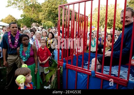 Präsident Barack Obama beobachtet, wie ein Kind versucht, während des Kongress-Picknicks auf dem South Lawn des Weißen Hauses, 25. Juni 2009, den Presseminister Robert Gibbs zu entweiden. Stockfoto