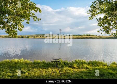 Karpfen angeln karpfen beißen Indikatoren und Rollen auf rod pod in der Nähe des Flusses. Angeln bei Sonnenaufgang. Stockfoto