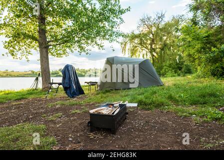 Angeln Adventures, Karpfen angeln. Angler, bei Sonnenuntergang, ist die Fischerei mit Karpfen angeln Technik. Camping am Ufer des Sees. Stockfoto