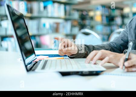 Studierende studieren in der Bibliothek mit Laptop an der Universität. Bildungskonzept. Stockfoto