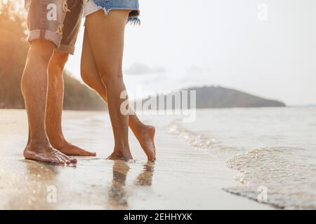 Die Beine des Paares stehen zusammen am Strand. Mann und Frau in der Liebe. Stockfoto