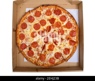 Draufsicht flache Lage einer ganzen Pepperoni Pizza in Scheiben geschnitten in der Box, isoliert auf weiß Stockfoto